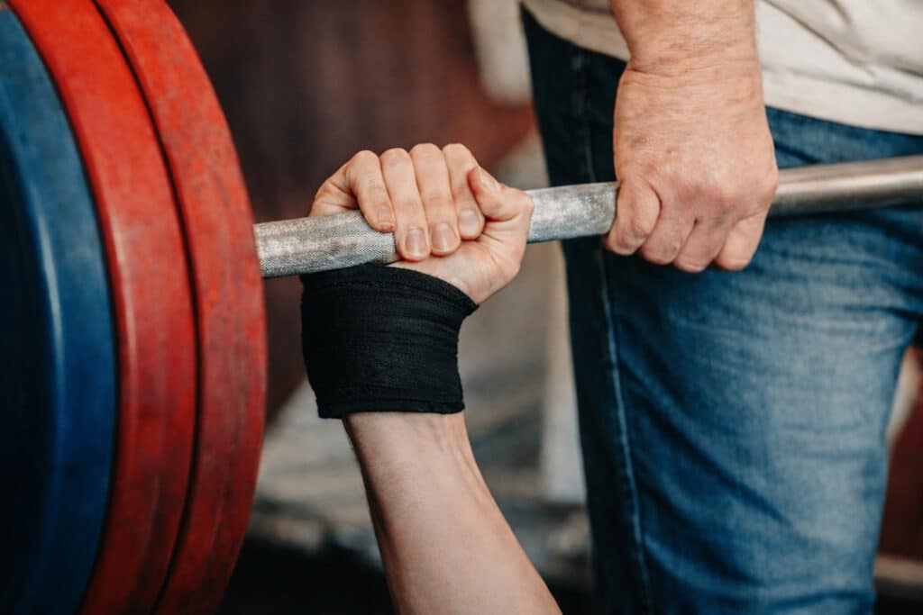 Grip width on the bench press affects three things that matter to competitive powerlifters: bar travel distance, shoulder position at the chest, and how work is distributed between the chest, shoulders, and triceps