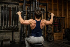 Powerlifter performing lat pulldown in a garage gym, illustrating lat strength development for improved deadlift performance