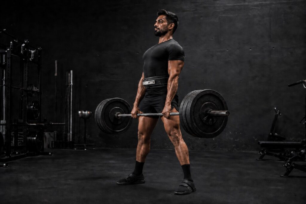 Powerlifter performing a heavy conventional deadlift in a gym while focusing on bar path, full-body strength, lifting technique, and efficient movement mechanics to improve powerlifting performance and maximize strength development.