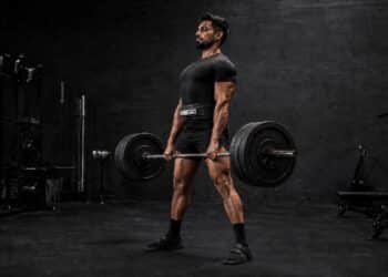 Powerlifter performing a heavy conventional deadlift in a gym while focusing on bar path, full-body strength, lifting technique, and efficient movement mechanics to improve powerlifting performance and maximize strength development.