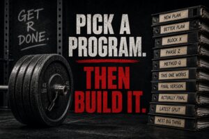 Powerlifting barbell with stacked plates beside binders labeled training programs, illustrating consistency vs program hopping in powerlifting